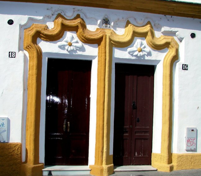 Chambranas (moldura) en Las puertas de entradas de las casas número 16 y 18 de la calle Velázquez. (San Fernando, Andalucía, España).
